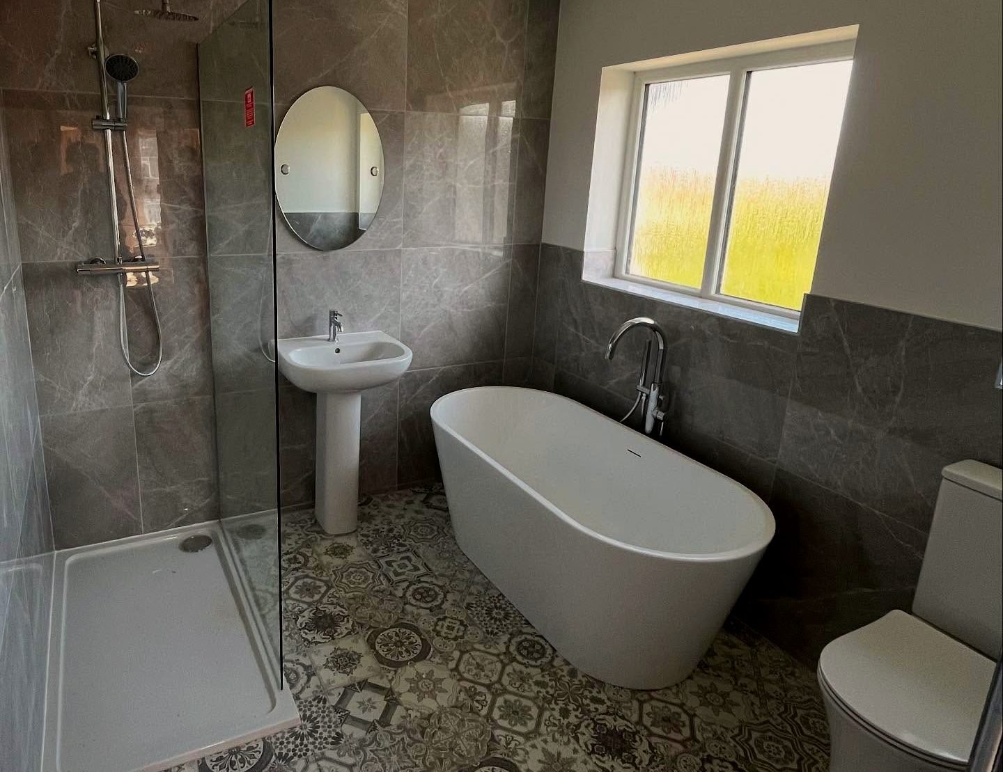 Renovated bathroom with freestanding bath and patterned floor tiles