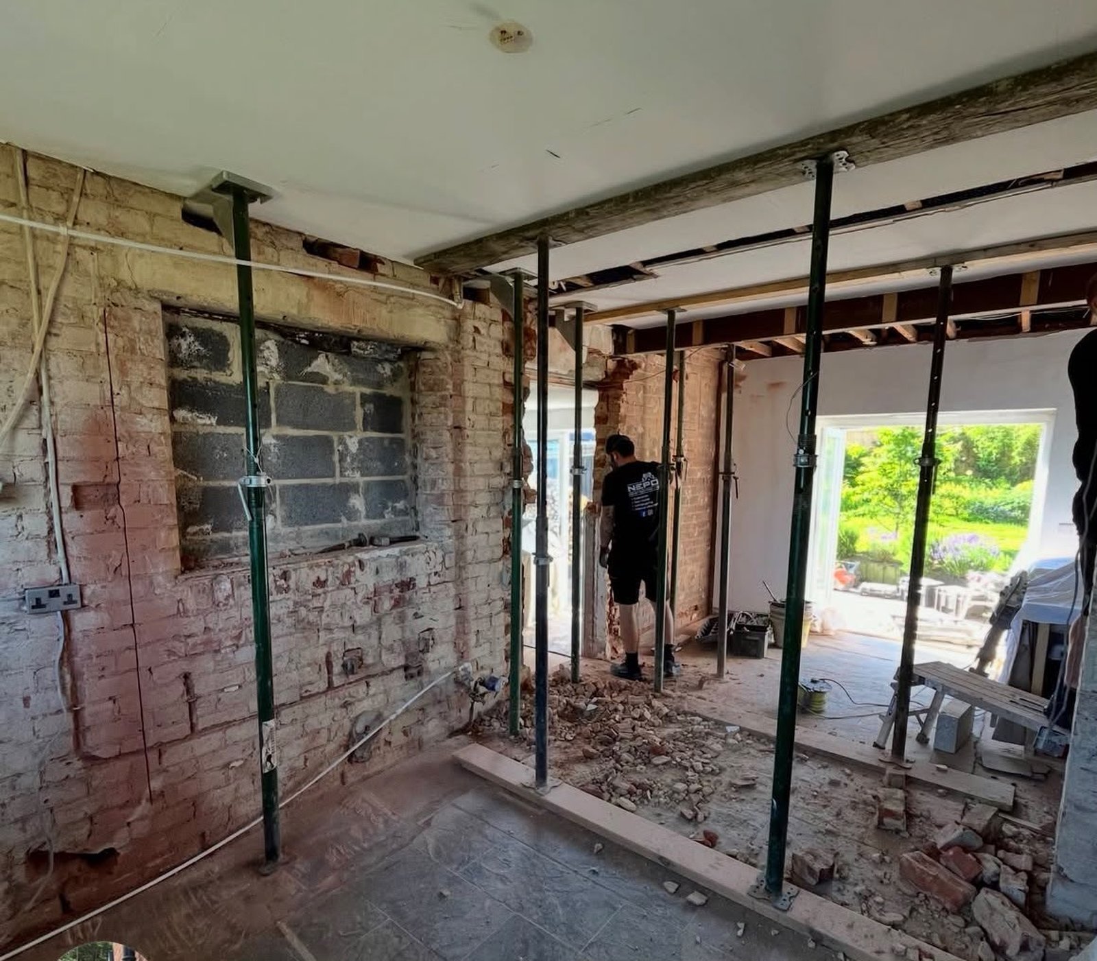 Temporary acrow props supporting the ceiling during a structural knock-through, ahead of the steel beam going in