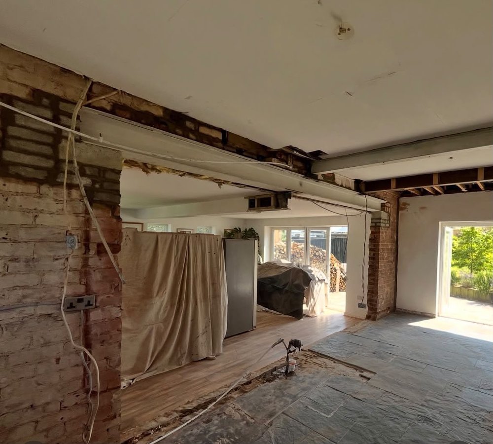 Finished open-plan living space with steel beam installed above, opening the ground floor into one large room